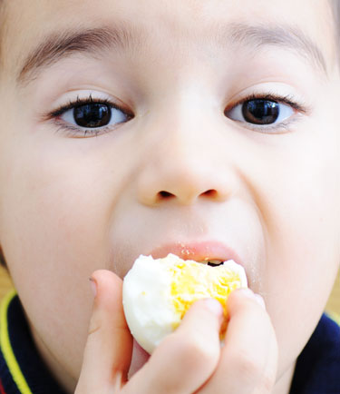 Niño comiendo huevo